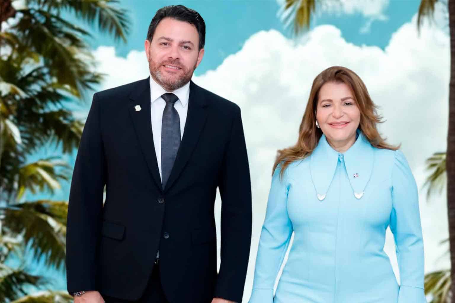 Ofrece una vista de un hombre y una mujer vestidos formalmente en un fondo con palmeras y cielo nublado, promocionando información de interés en Ocoa para el Radar Informativo de Ocoa.